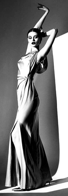 Woman in a long dress posing dramatically in a black and white studio shot