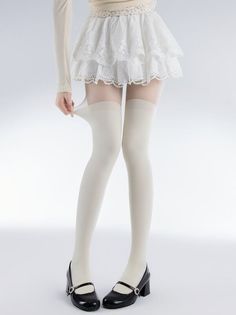 Person in a white lace skirt and thigh-high socks with Mary Jane shoes