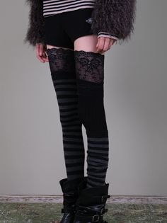 Person wearing thigh-high lace-trimmed striped socks and black boots