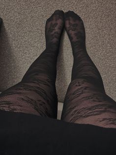 Person wearing black lace pattern tights indoors