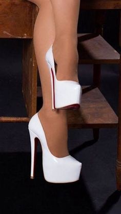 Person wearing white platform high heels with red soles