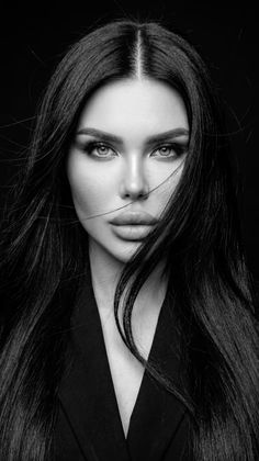 Woman with long black hair and dramatic lighting in a black and white portrait
