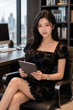 Woman in a black dress holding a tablet in an office setting