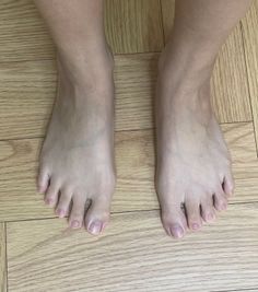 Bare feet on a light wooden floor viewed from above