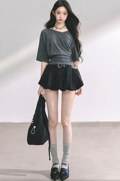 Woman with long black hair wearing a mini skirt and a choker indoors