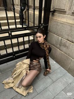 Woman in a leopard print outfit and black top posing outdoors