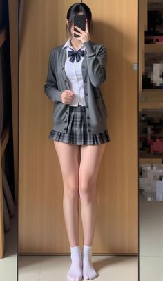Person in a school uniform taking a mirror selfie