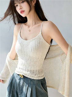 Woman with long hair wearing a white camisole and knitted cardigan