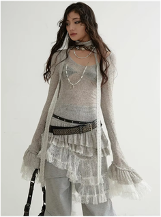 Woman with long hair wearing a sheer top and layered ruffled skirt