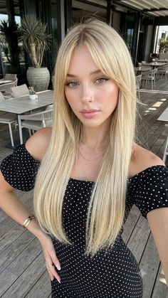 Woman with long blonde hair wearing an off-shoulder polka dot dress outdoors