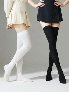 Two people wearing mini skirts and thigh-high socks in a studio setting