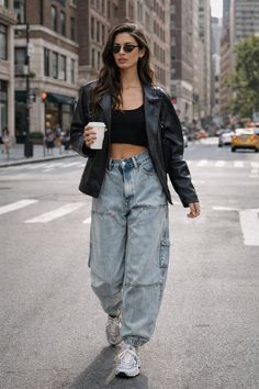 Woman in a black crop top and baggy jeans walking on a city street