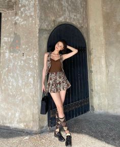 Woman in a floral pleated skirt and argyle socks posing outdoors