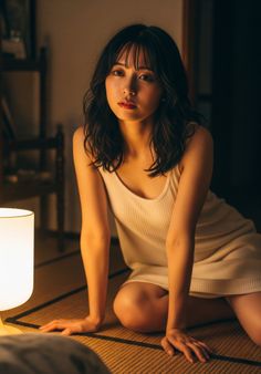 Woman with short dark hair in a tank top kneeling on a tatami mat