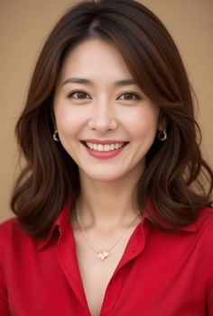 Woman with long brown hair wearing a red shirt and gold jewelry, smiling