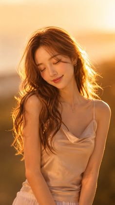 Woman with long wavy hair in a cowl neck top during golden hour