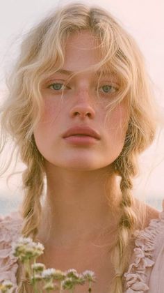 Close-up portrait of a blonde woman with braids and freckles