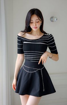 Woman with long black hair wearing an off-shoulder striped top and mini skirt