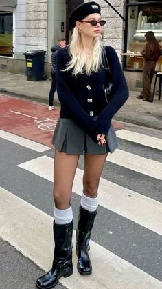 Woman with blonde hair wearing a beret, mini skirt, and black boots on a street