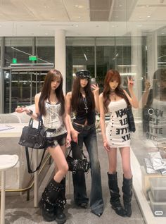 Three women in gothic-inspired outfits posing indoors