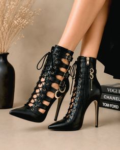 Pair of black lace-up high heels with gold accents and charms