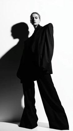 Woman in an oversized black suit with dramatic lighting and shadow