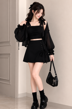 Woman in a black crop top, mini skirt, and sheer jacket indoors