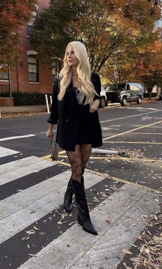 Woman with long blonde hair in a black blazer and patterned tights on a street