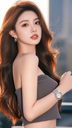 Woman with long brown hair wearing a strapless top and watch