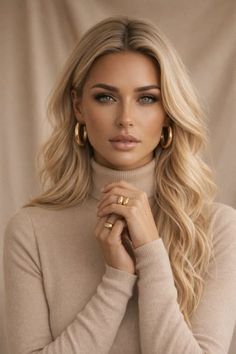 Woman with blonde hair wearing a turtleneck sweater and gold jewelry