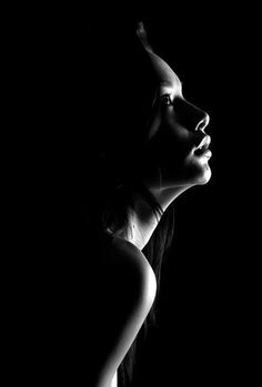 Woman's profile in dramatic black and white lighting with exposed shoulder