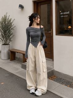 Woman in an off-shoulder top and cargo pants standing outdoors