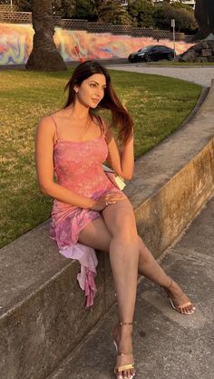 Woman in a pink dress sitting outdoors during golden hour