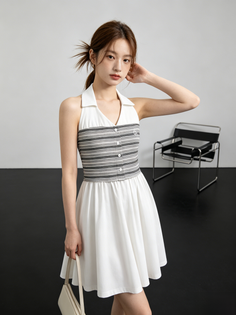 Woman in a white halter dress with a striped top and a ponytail indoors