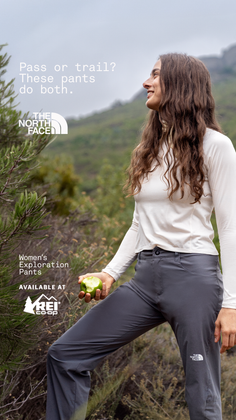 Woman in hiking gear holding an apple outdoors