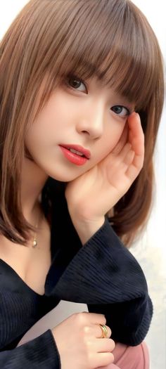 Woman with brown hair and red lipstick wearing a black top and gold jewelry
