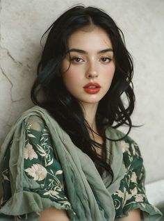 Woman with long dark hair and red lipstick wearing a green floral dress