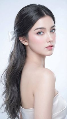 Woman with long black hair and a white ribbon in a strapless top