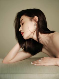 Woman with long dark hair and red lipstick in a provocative pose