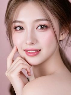 Woman with long brown hair and pink makeup against a pink background