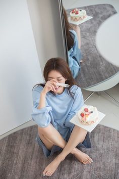 Woman in a blue striped shirt sitting on the floor with a cake