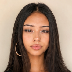 Woman with long dark hair and a hoop earring looking directly at the camera