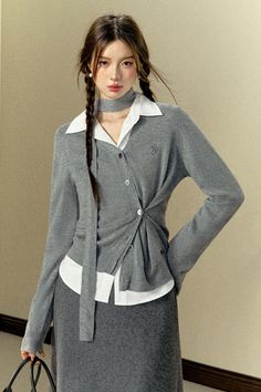 Woman with braided long hair wearing a gray cardigan and white shirt