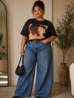 Woman with curly hair in a high bun wearing a black t-shirt and wide leg jeans