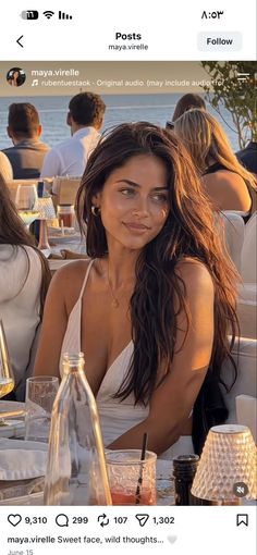 Woman with long hair in a white dress at an outdoor restaurant during golden hour