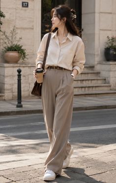 Woman in a button-up shirt and wide-leg pants walking on a street