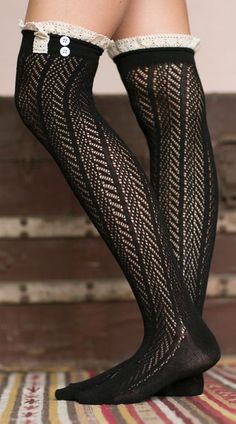 Close up of legs wearing black patterned stockings with lace trim and buttons
