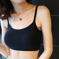 Woman wearing a black spaghetti strap top and a necklace