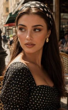Woman in a polka dot dress and headband outdoors with soft lighting