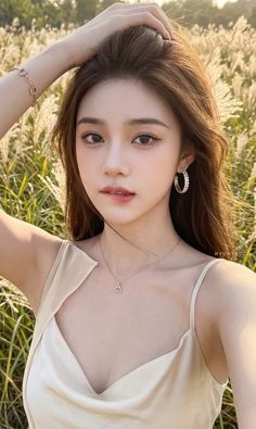 Woman with long hair wearing a light colored top and jewelry outdoors